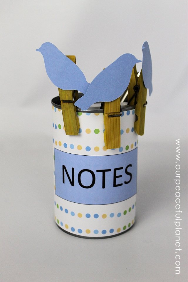 This upcycle project would make a great useful gift! Its a little birds on a wire note holder set made from clothespins and a can. Add in some string and paper and they can make a hanging note center! Comes with FREE PRINTABLES!