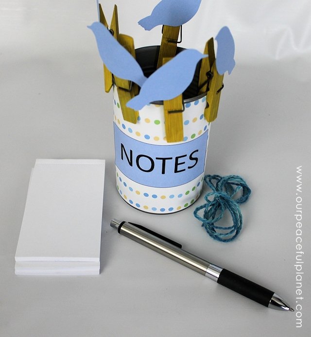 This upcycle project would make a great useful gift! Its a little birds on a wire note holder set made from clothespins and a can. Add in some string and paper and they can make a hanging note center! Comes with FREE PRINTABLES!