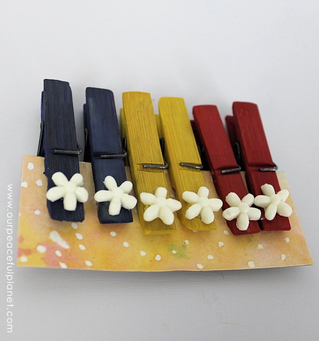 These pretty clothespin gift sets are inexpensive to make and come with a very unique display holder.  The perfect present for a variety of occasions they can be used for a many things from note and photo holders, to bag clips. 