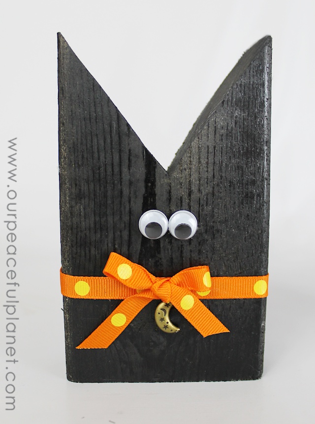 Make this simple black cat Halloween craft from 2x4 pieces, a little paint, ribbon and wiggle eyes! An inexpensive way to decorate your house for Halloween! 