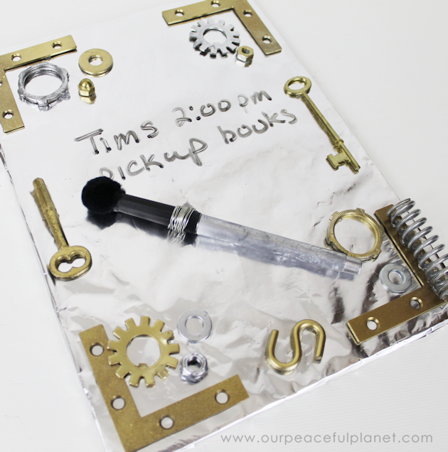 This simple DIY Steampunk dry erase board is perfect for keeping track up upcoming events or reminders. All you need is foil, foam board and metal parts!