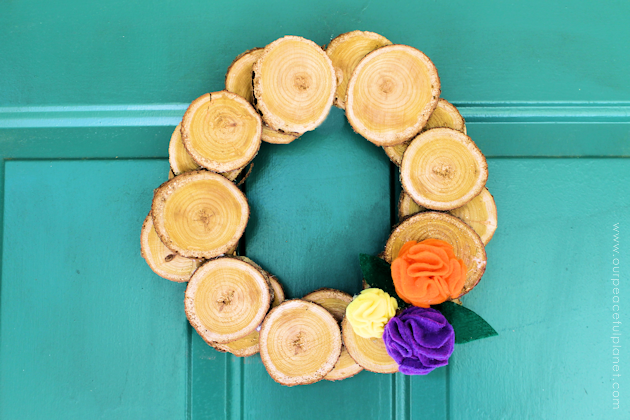 Make this easy & inexpensive fall wreath with some wood slices and hot glue! You can place a few flowers of choice on it. We used our 5 minute felt flowers.