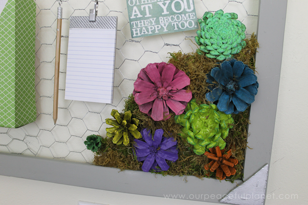A country chicken wire frame memo board that will brighten up your kitchen with its pretty pinecone succulents. It holds useful items plus photos & quotes!