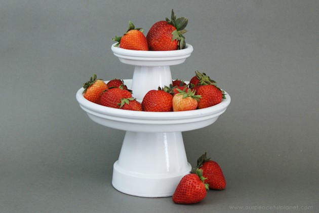 This small DIY cake stand can hold so much more! Fruit, cookies, nuts, candy, tea bags etc. Made from clay pots it’s simple and inexpensive to make. 