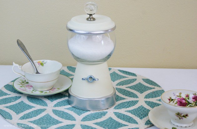 This elegant DIY sugar dispenser will add some beauty to your kitchen. It's made from a clay pot and a glass bowl and is inexpensive and simple to create!