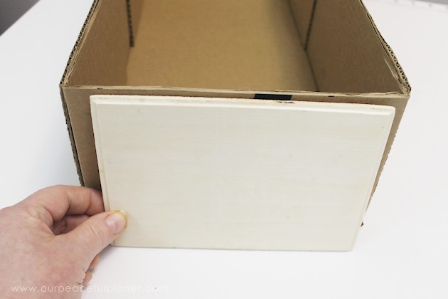 Learn how to make an inexpensive pull out cabinet organizer using a cardboard box so you can easily access things in the far reaches of your lower cabinets.